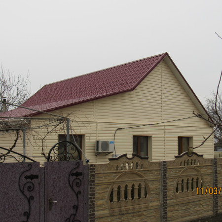 Вид дома из-за забора