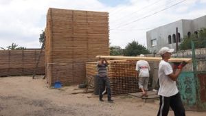 Кровельщики грузят лес Работа по погрузке кровельного леса